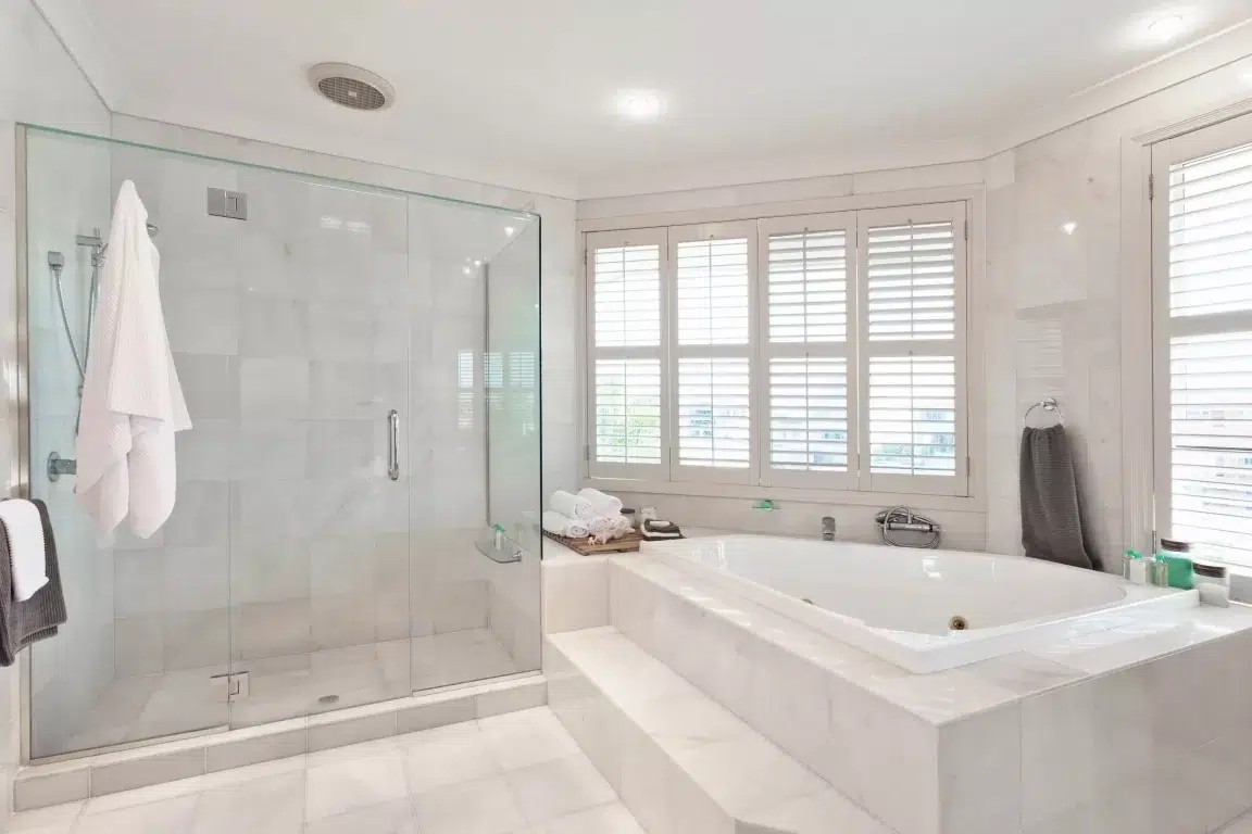 Renovated master bathroom with glass shower and freestanding tub